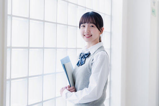 教材を持って校内を歩く女子高生