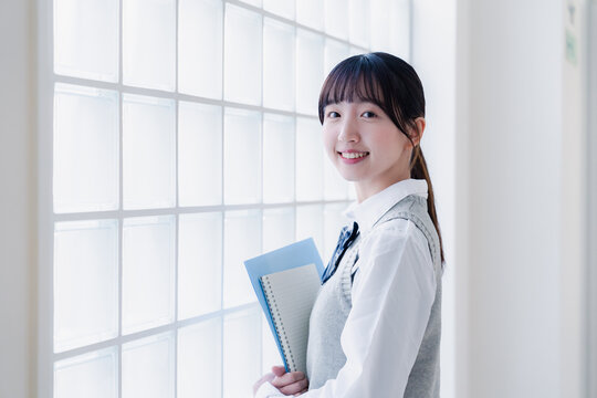 教材を持って校内を歩く女子高生