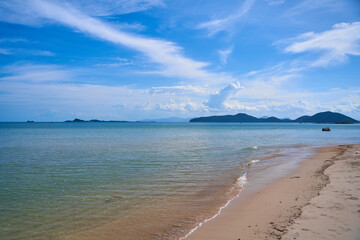 Fototapeta na wymiar View from the sandy beach to the silhouettes of islands in the sea. Beautiful beach of Thailand