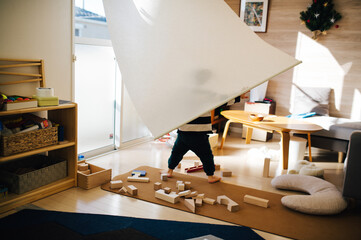 おもちゃが散乱した子供部屋で遊ぶ子供