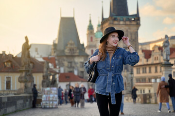 Female traveller tourist on the Charles Bridge in Prague, Czezh Repubic. Stylish beautiful young...