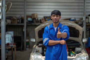 portrait of positive asian auto mechanic in uniform posing Thumbs up