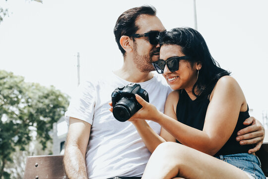 Photograph of a couple looking at photos on a reflex camera. Lifestyle concept and people.