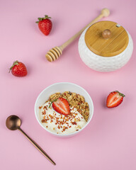 Healthy food concept: homemade granola with yogurt and strawberries. Oatmeal with freeze-dried strawberries, fresh berries and honey. Delicious and healthy breakfasts.