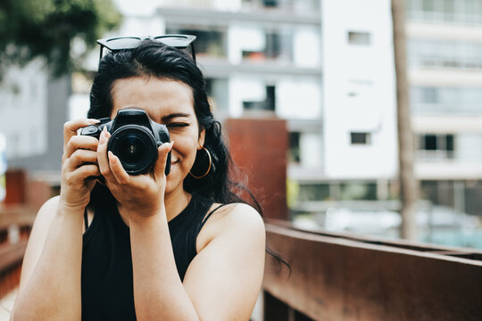 Photograph of photographer holding her reflex camera. Lifestyle concept and professions.