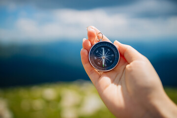 Traveler with compass seeking a right way in the mountains during hike. Navigation concept in explore travel. © Shi 