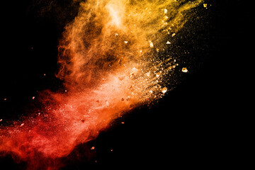 Split debris of  stone exploding with orange red powder splash against black background.