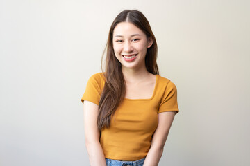 Cheerful Young asian woman standing and smiling isolated on background