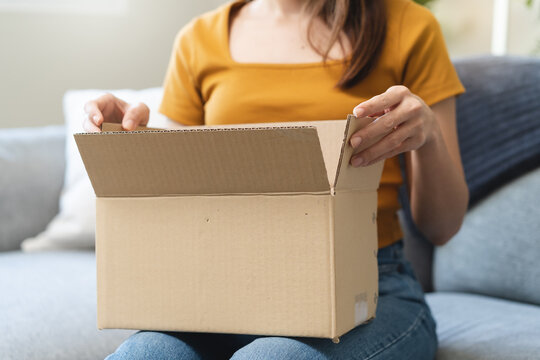 Close-up Hands Of Excited Young Females Opening Box At Home