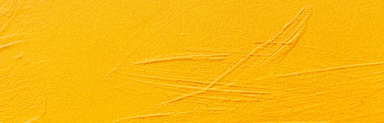 Abstraction. Texture of a painted yellow wall close-up with brush texture lines
