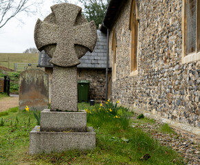 Close and selective focus on an ornate cross headstone in a church yard