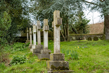 Row of ornate cross headstones in a churchyard with selective focus