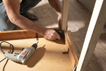 Caucasian carpenter repairing broken table.