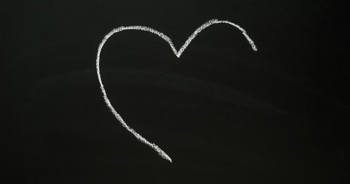 Heart drawn with white chalk on a chalkboard. Looped 4K stop motion animation