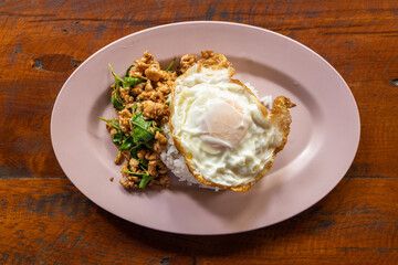 Overhead view of Prad Ka Pao, popular Thai steet food made up of fried minced pork with basil and fried egg with rice