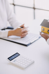 House model with real estate agent and customer discussing for contract to buy house, insurance or loan real estate background.