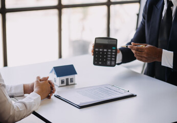 House model with real estate agent and customer discussing for contract to buy house, insurance or loan real estate background.