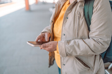 Woman using in hands gadget mobile phone, woman texting message on blank screen smartphone, texting message, mockup online wifi internet concept, hipster waiting on station platform on back