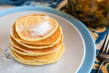 classic american breakfast. homemade banana pancakes on plate sprinkled powder and honey. Pancakes on the kitchen table . Pancake slide with honey topping . High quality photo