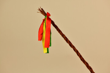 Traditional Czech Easter whip with colored ribbons 
from willow branches on the light background 