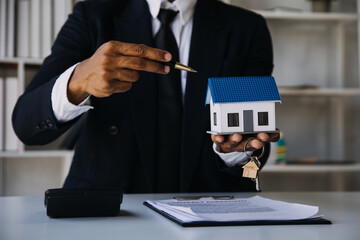 House model with real estate agent and customer discussing for contract to buy house, insurance or loan real estate background.
