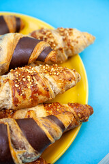 Chocolate croissants or croissant with nut crumbs on a plate. Delicious breakfast on the table. Tasty sweet baking dessert for coffee. Food background. Fresh buttery croissants rolls