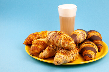 Chocolate croissants or croissant with nut crumbs on a plate. Delicious breakfast on the table. Tasty sweet baking dessert for coffee. Food background. Fresh buttery croissants rolls. Copy space