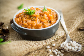 beans stewed with vegetables and spices, in a bowl .