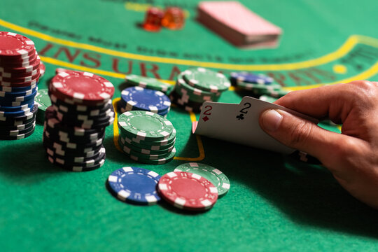 Casino, gambling and entertainment concept - stack of poker chips on a green table.