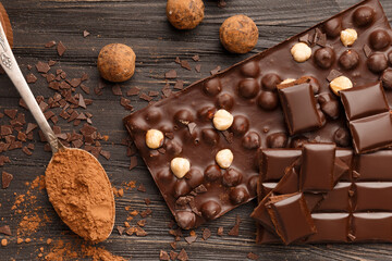 Chocolate with raisins and nuts on a dark wooden background close-up.