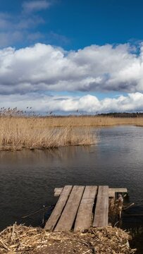 4k timelapse of Braslaw lake Dryaviaty in Belarus with pier and clouds. Vertical video