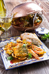 Traditional Portuguese seafood cataplana with king prawns, mussels and fish in wine sauce served as...