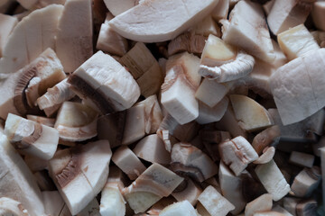 Raw mushrooms are cut into small pieces. Raw chopped champignons. Chopped mushrooms for salad