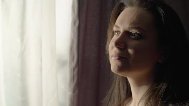 Close-up of a girl drinking morning coffee by the window. The beginning of a new day. Happy woman. High quality 4k footage