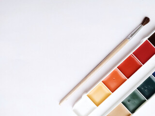 Brush and paint on a white background. Everything for drawing. Creation. Children are creativity. Hobby. Colored paints