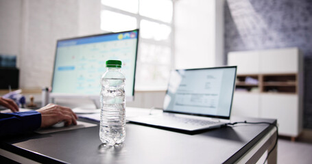 Water Bottle On Desk And Man In Background
