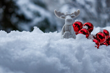 White Elk Figurine with Gift and Red Christmas Ornaments in Snow