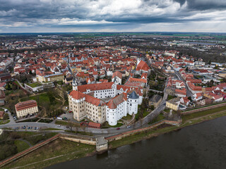 Fototapeta na wymiar city view of torgau in rainy weather. Hartenfels Castle in the center. dark clouds frame the city center