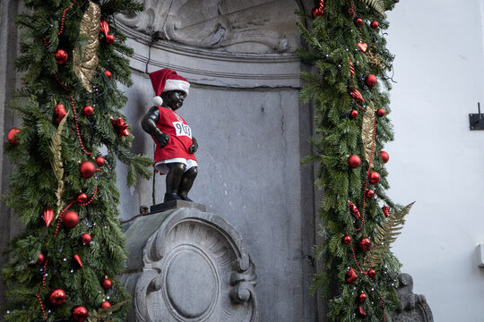 BRUSSELS, BELGIUM-DECEMBER 26, 2022: Manneken Pis (pissing boy, peeing boy) fountain sculpture in Christmas time