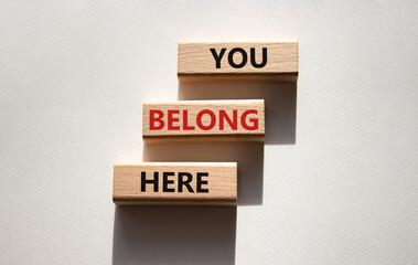 You belong here symbol. Wooden blocks with words You belong here. Beautiful white background. Business and You belong here concept. Copy space.