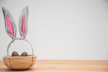 chocolate eggs in a basket with bunny ears. Easter background.