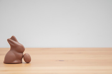 Chocolate bunny and chocolate eggs on a wooden table. Easter background.