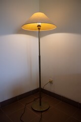 Interior with floor lamp and glow bulb in the dark at night, one lamp in the corner against a floor lamp wall.