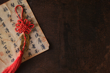 Chinese lucky coins with artfully tied knots for good fortune and success on dark rusty background...