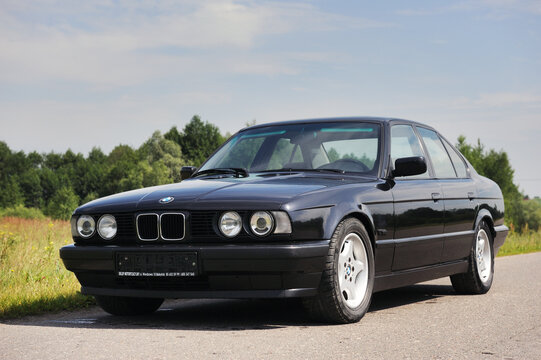 Belarus, Minsk-02.07.2012:Black classic car BMW E34 5-series on the autumn road.