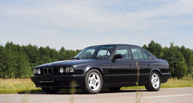 Belarus, Minsk-02.07.2012:Black classic car BMW E34 5-series on the autumn road.