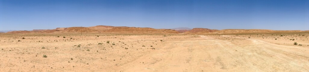 Fototapeta na wymiar Panorama view of the hot dry moroccan desert in the midday sun