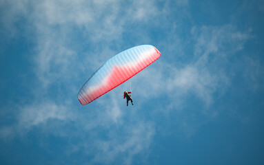 Gleitschirmsegler schwebt vor blauem Himmel, Lauterbrunnental, Kanton Bern, Schweiz
