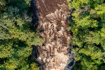 Muddy river rapids seen from the air in a nadir view.