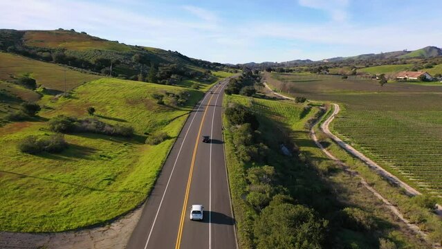 2023 - Excellent aerial footage of cars driving past farmland in Lompoc, California.
